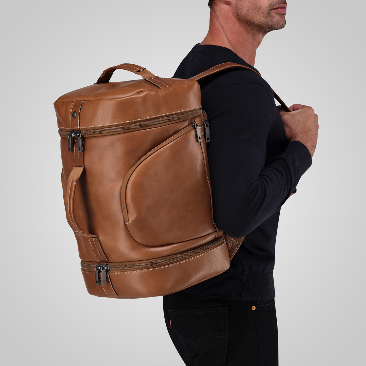 Jekyll and Hide - Large Travel Backpack - Colt - OVERSIZE PARCEL worn by a man on his shoulder, showcasing its stylish leather design.