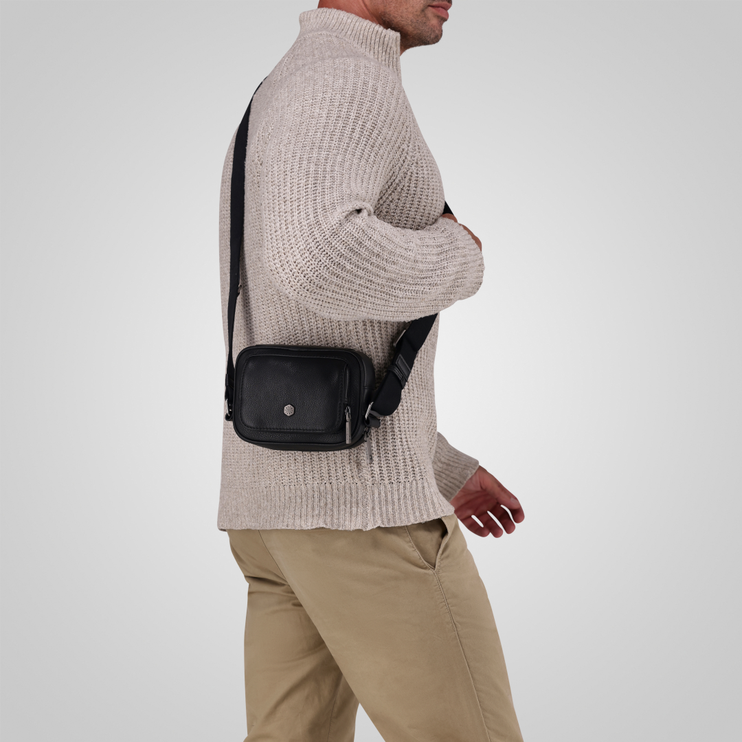 Jekyll and Hide - Small Travel Crossbody Bag - Mocha worn by a man in a cozy sweater, featuring an adjustable strap.