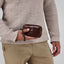 Jekyll and Hide - Compact Zip Around Cable Pouch - Tan | Black | Mocha held in hand, showcasing elegant design and functionality.