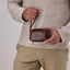 Jekyll and Hide - Compact Zip Around Cable Pouch - Tan | Black | Mocha held by a man in a cozy sweater.