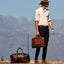 Jekyll and Hide - Medium Laptop Briefcase - Colt | Mocha held by a man in a stylish outfit with a scenic backdrop.