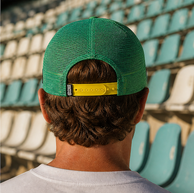 FIFA World Cup Australia Cap - Green. Man wearing a green and yellow cap with a logo in an outdoor setting.