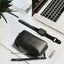 Jekyll and Hide - Compact Zip Around Cable Pouch - Tan | Black | Mocha alongside tech accessories on a desk.