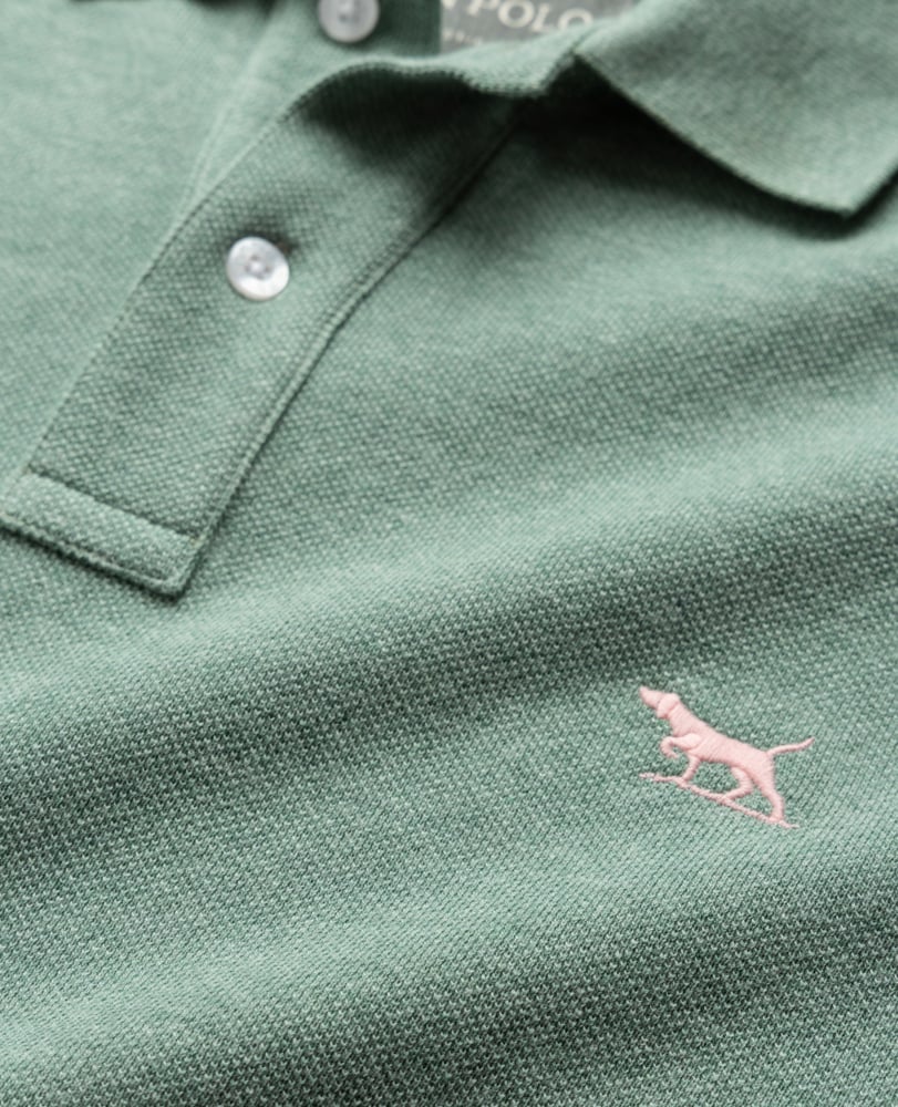 Rodd & Gunn - The Gunn Polo - Dusty Sage - MULTIBUY close-up showing the iconic pink pointer dog logo on a green cotton-pique fabric.