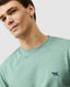 Rodd & Gunn - The Gunn T-Shirt 2.0 - Dusty Sage - MULTIBUY worn by model, showcasing iconic pointer embroidery.