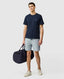 Rodd & Gunn - The Gunn T-Shirt 2.0 - Midnight - MULTIBUY worn by a model with a duffel bag and shorts.