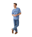 R.M.Williams - Outfitter T-Shirt - Soft Blue worn by a model, featuring crew neck and branded print.