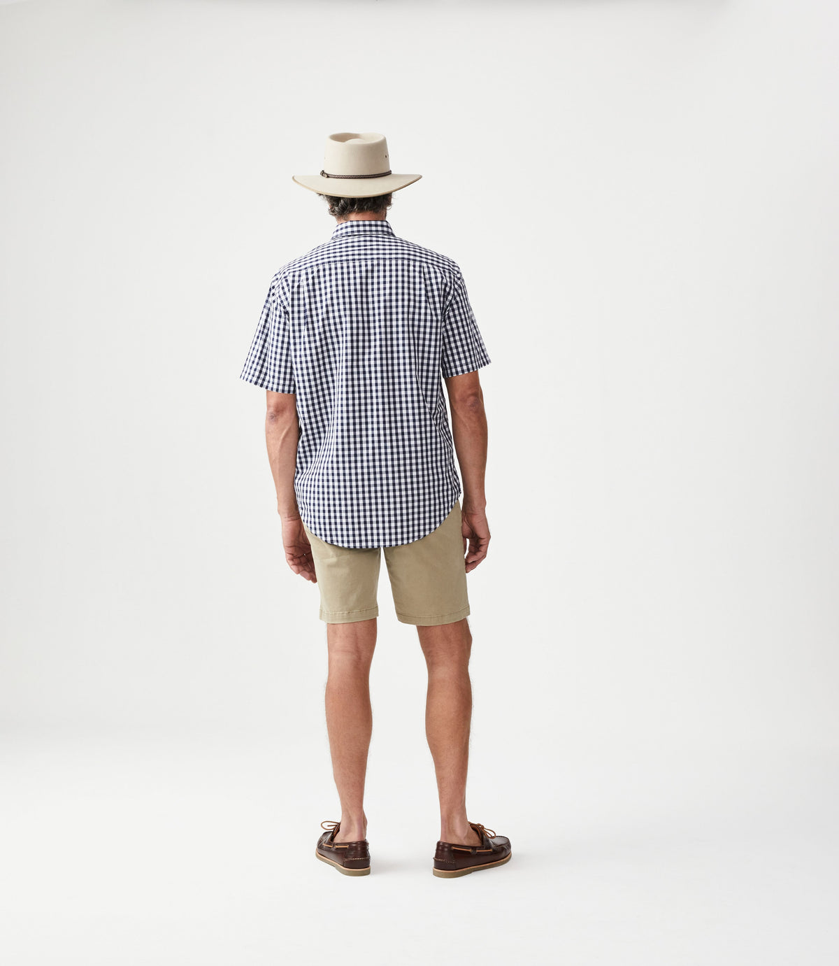 R.M.Williams - Hervey Shirt - Short Sleeve - Check - Navy & White worn by a man from the back, paired with shorts and a hat.