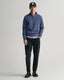GANT - Sacker Rib Half-Zip Sweatshirt - Dark Jeans-Blue Melange worn with black pants and cap, showcasing a smart-casual look.