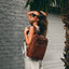 Jekyll and Hide - Ladies Business Backpack 38cm - Black | Tan being worn by a model with sunglasses and palm background.