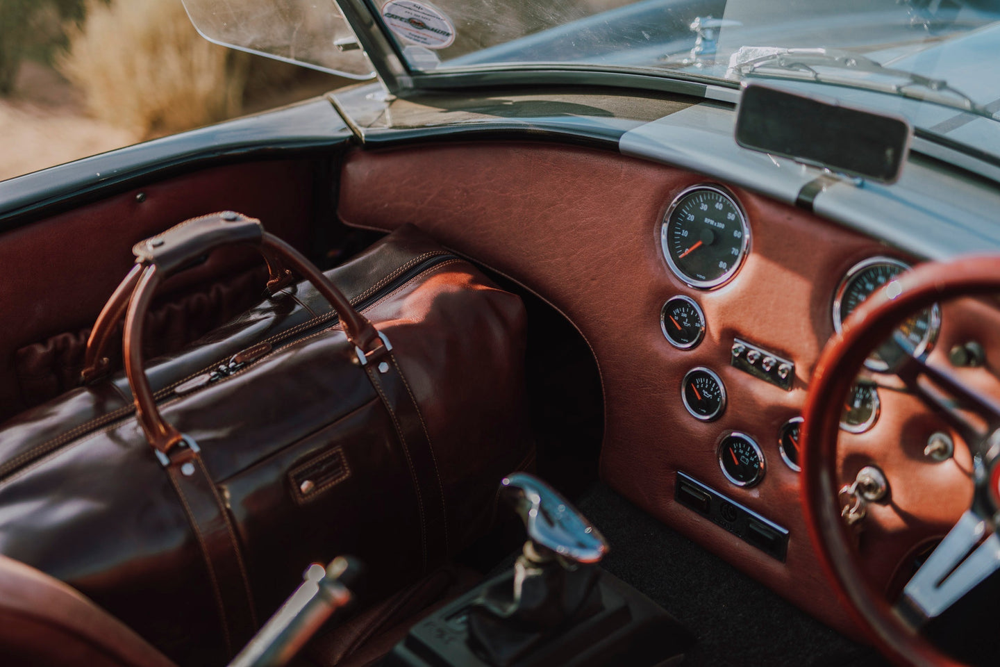 Interior of a classic car showcasing a luxury leather bag and dashboard details.