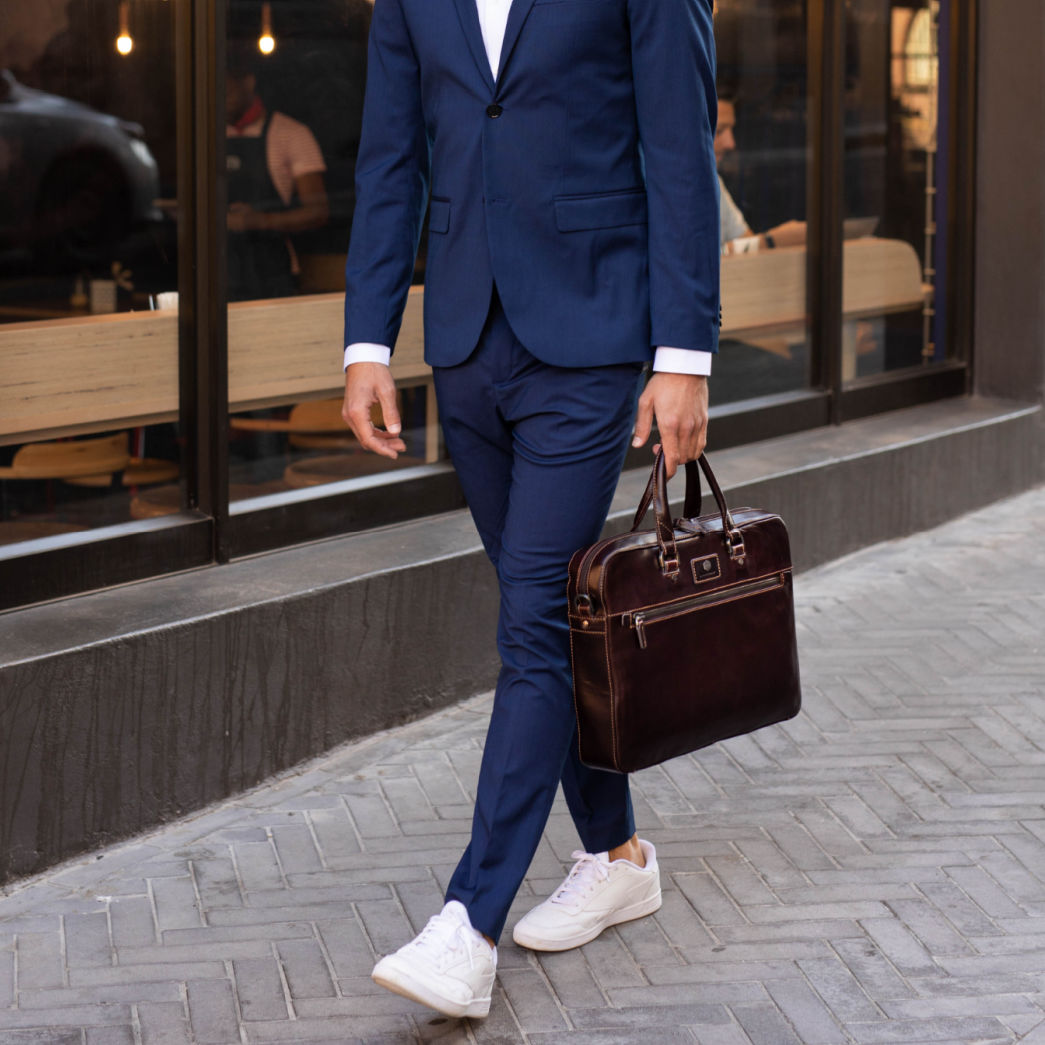 The Complete Guide to Men's Suit Size: How to Find Your Perfect Fit with a man in a blue suit carrying a briefcase.