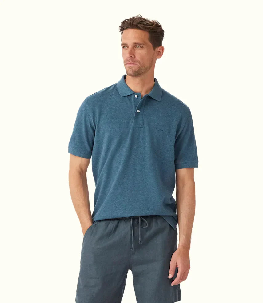 Why Polo Shirts Are a Timeless Staple in Every Man’s Wardrobe - Model wearing a blue polo shirt with shorts.