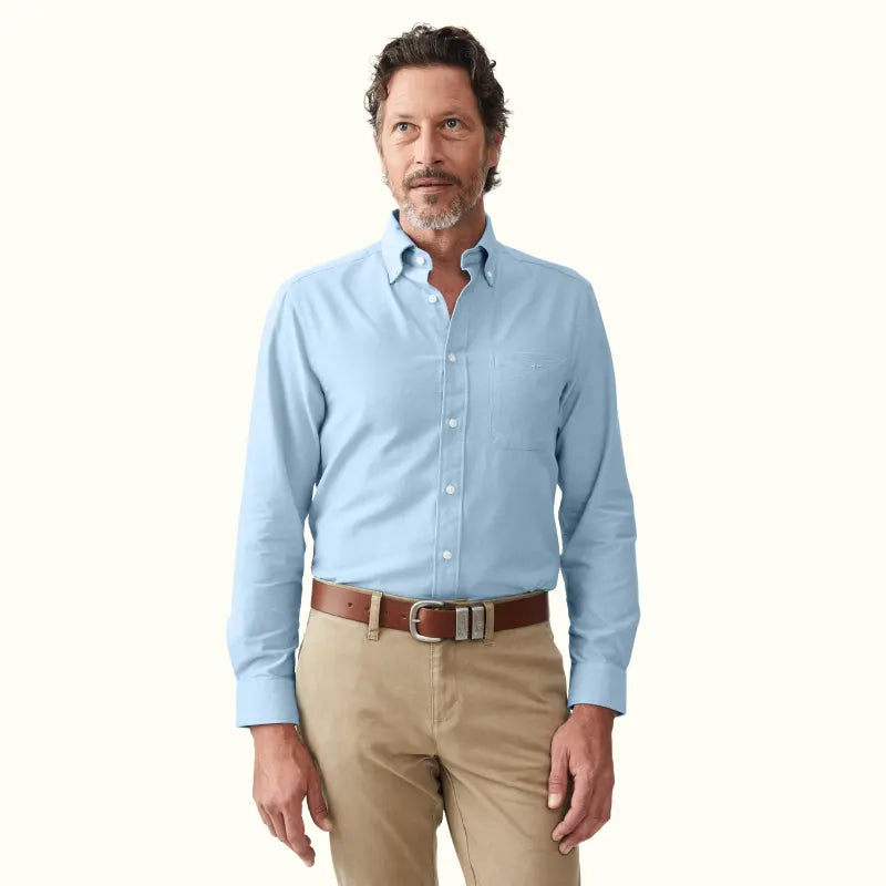 How to Wear Polo Button-Down Shirts for a Smart-Casual Look: A man in a light blue button-down shirt styled for smart-casual elegance.