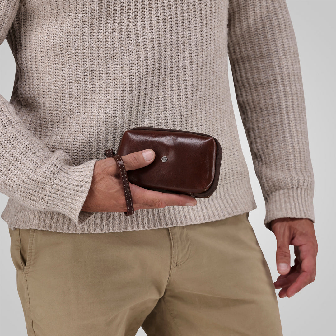 Jekyll and Hide - Compact Zip Around Cable Pouch - Tan | Black | Mocha held in hand, showcasing elegant design and functionality.