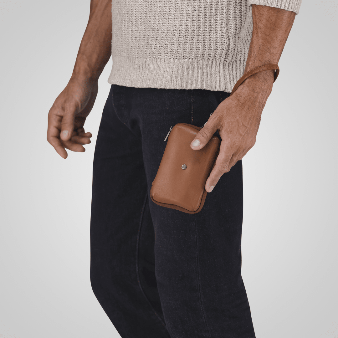 Jekyll and Hide - Compact Zip Around Cable Pouch - Tan | Black | Mocha being held by a man in casual attire.