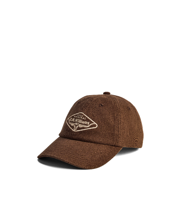 A brown washed cotton baseball cap with a curved brim, featuring a cream embroidered diamond logo on the front that reads 'The Art of Williams'.