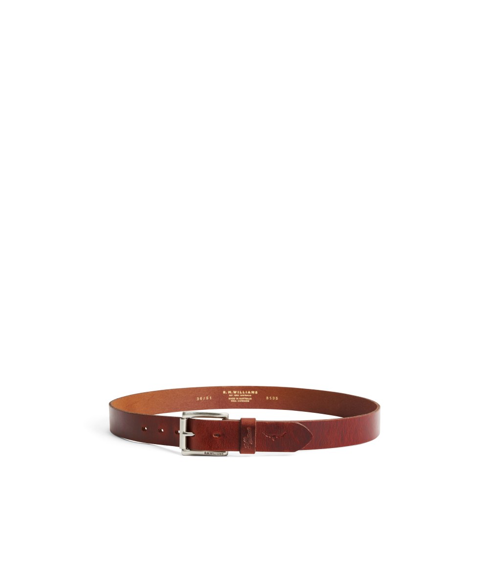A brown leather belt with a silver metal buckle, displayed in a curved loop shape on a clean white background. The brand name 'KASPARIS' is printed in gold on the inside of the belt.