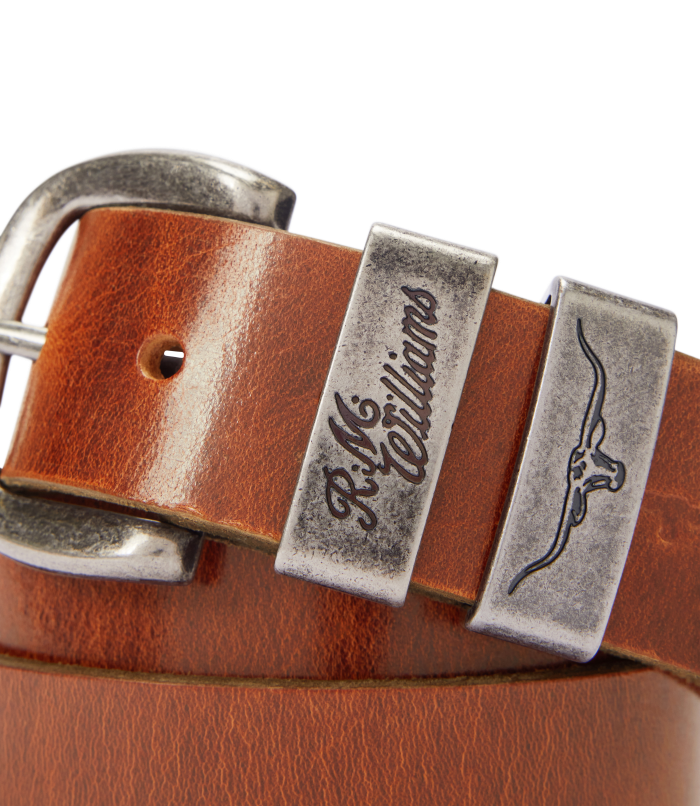 R.M.Williams - Drover Belt - Dark Bronze Hardware - Mid Brown close-up showcasing the iconic logo and double keepers.