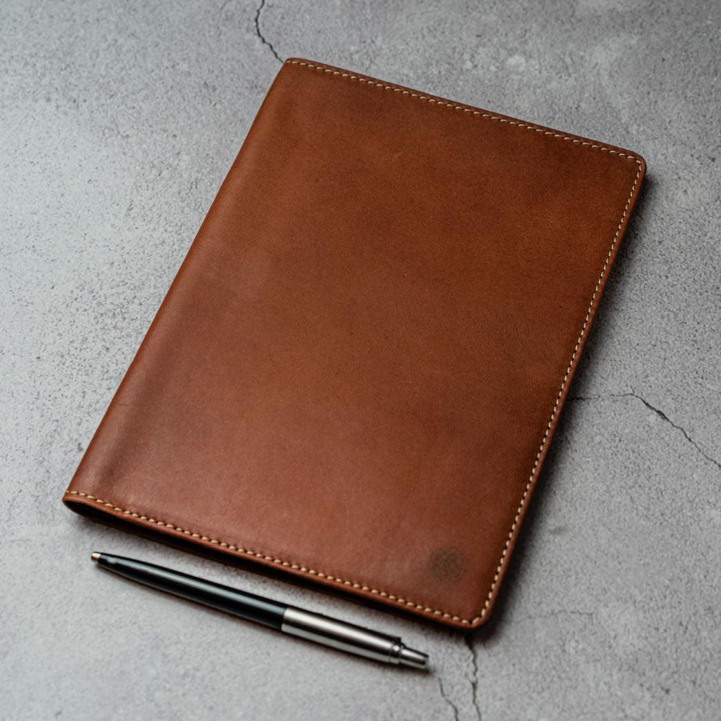 Jekyll and Hide - Leather A5 Notebook Cover - Tan | Mocha | Black | Lollipop on a textured surface with a pen.