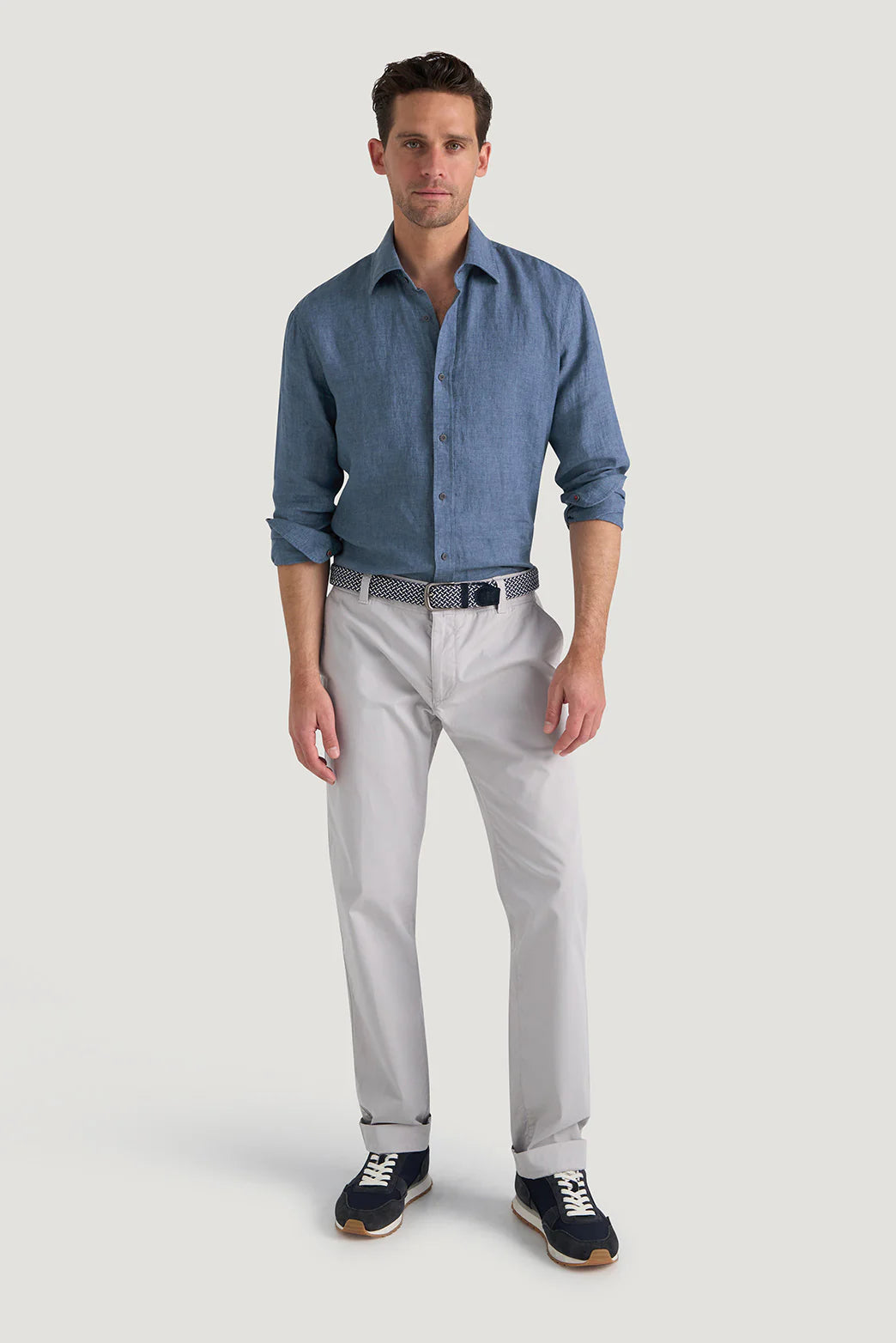 M.J. Bale - Bradfield Linen Shirt - Coastal Indigo - MULTIBUY worn by a model with light trousers and sneakers.