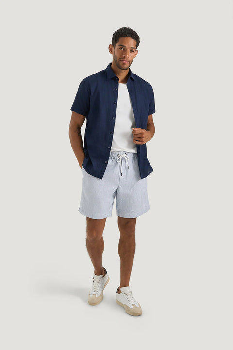 M.J. Bale - Byron Linen Blend Short - Stripe - Blue & White worn by a model, styled with a navy shirt and sneakers.