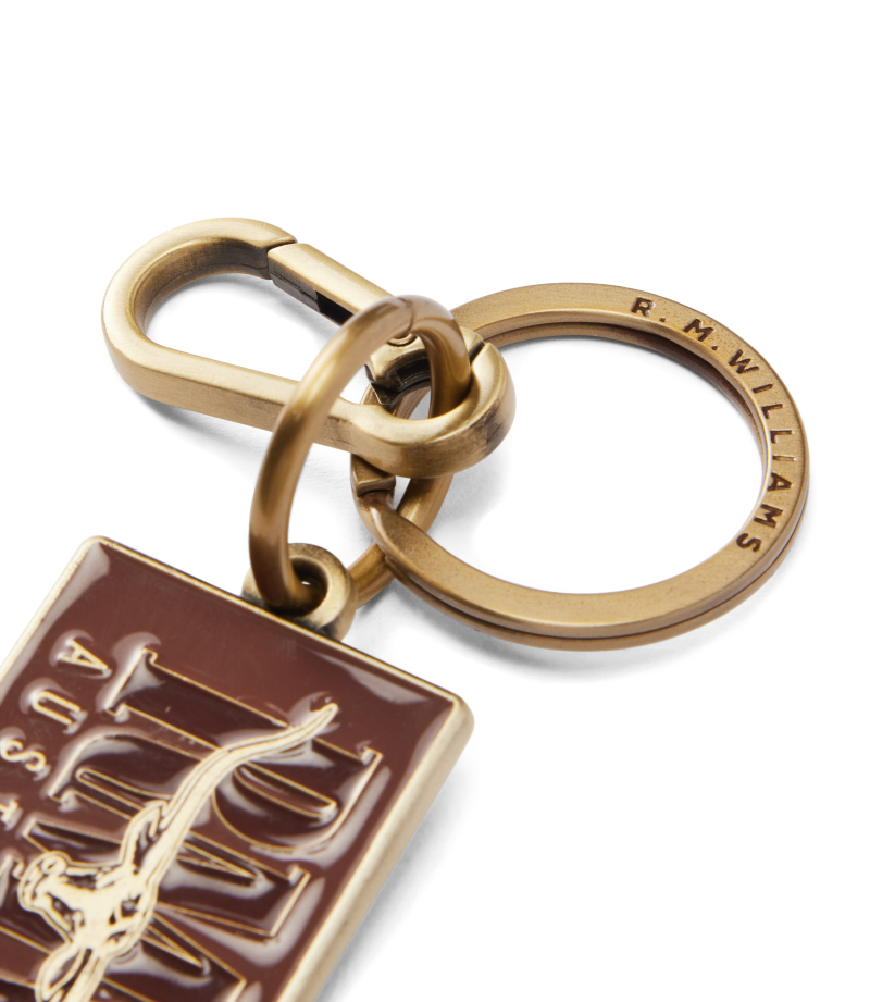 R.M.Williams - Heritage Logo Enamel Keyring - Chestnut with brass hardware and spring-loaded snap hook.