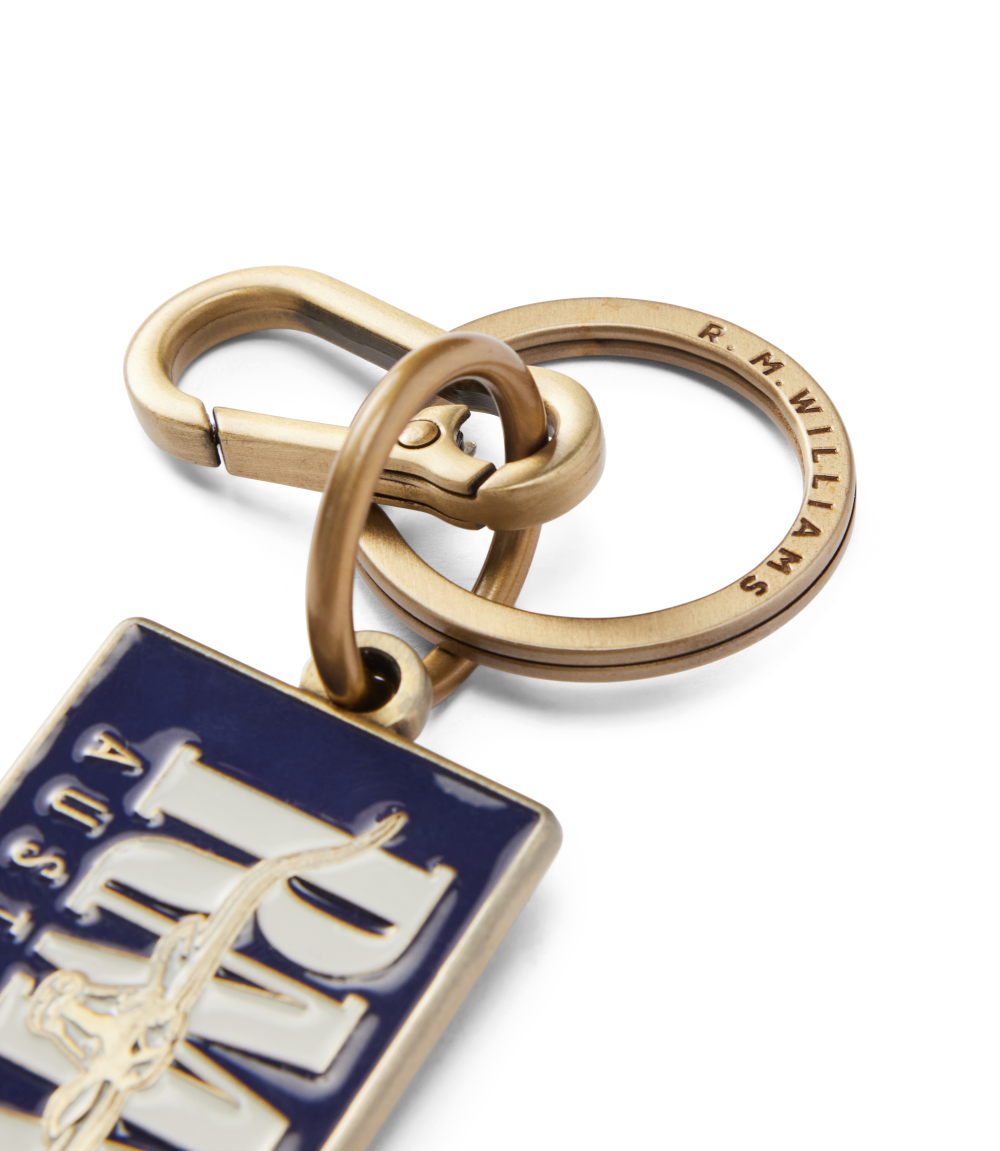 R.M.Williams - Heritage Logo Enamel Keyring - Navy featuring a gold clasp and logo detail.