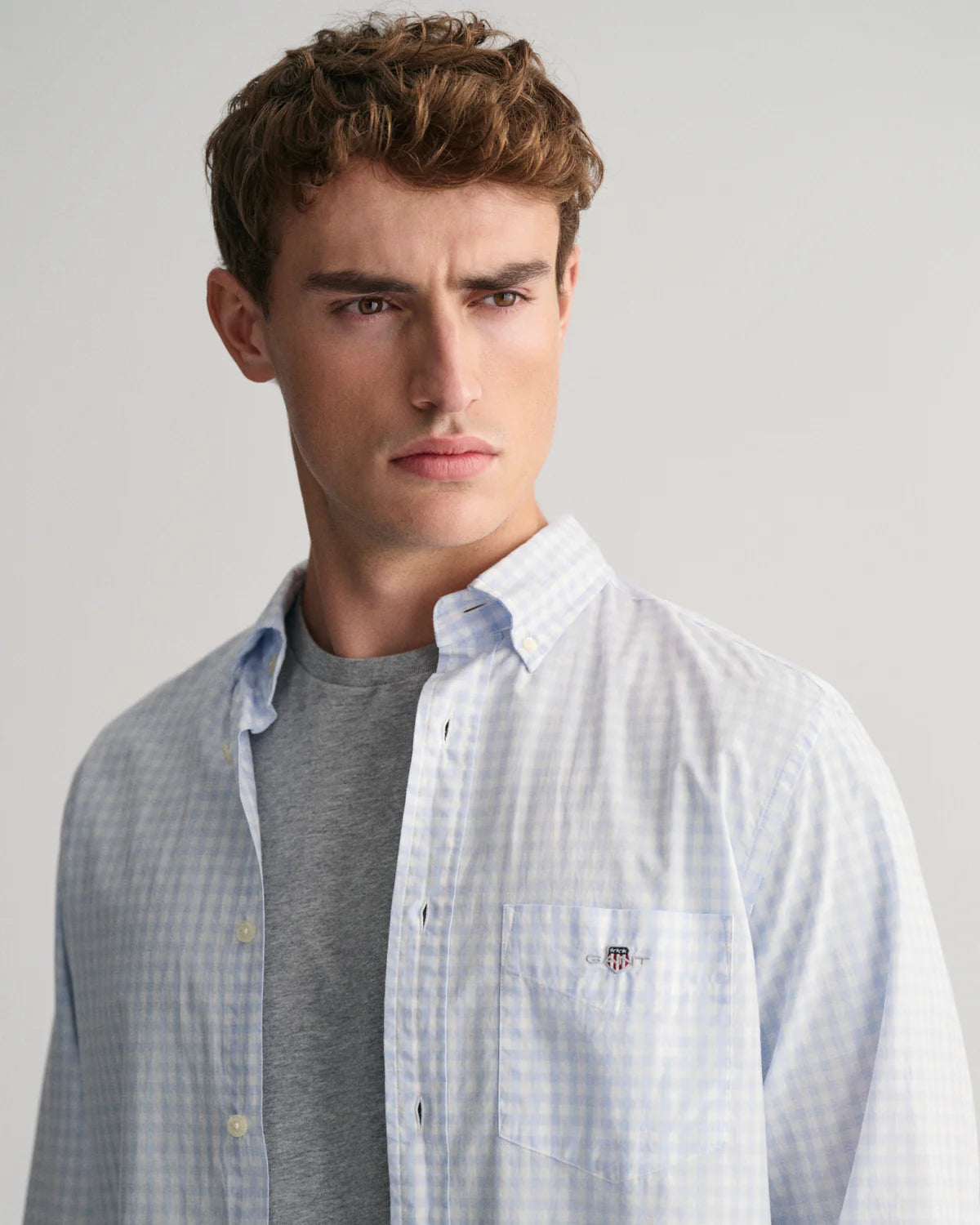 GANT - Poplin Shirt - Gingham - Light Blue & White worn by a model showcasing its stylish design and GANT shield detail.