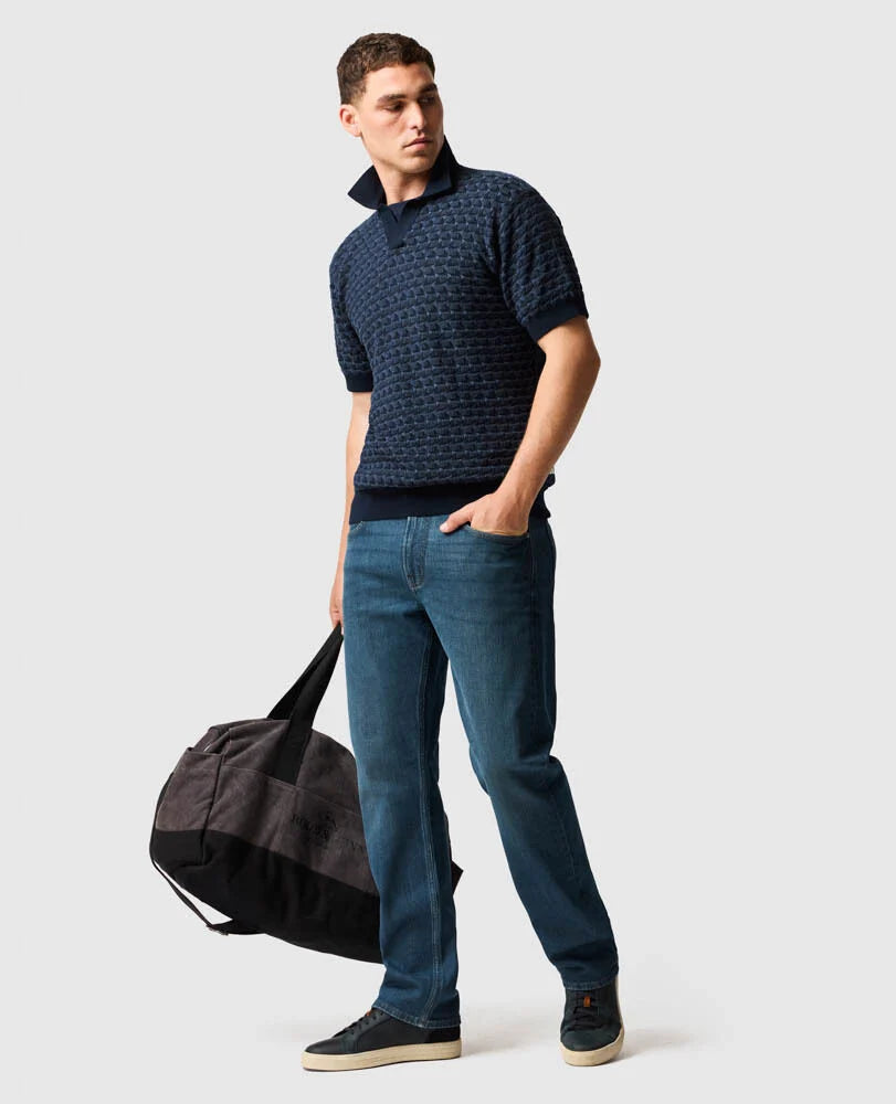 Rodd & Gunn - Halken Knit Polo - Midnight worn by a model with jeans and a bag, showcasing modern relaxed sophistication.