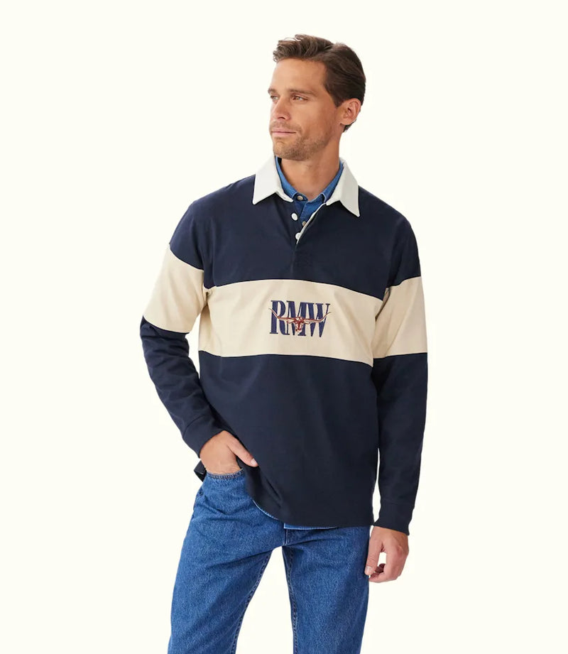 Man wearing a navy and beige rugby-style shirt with a logo on a white background