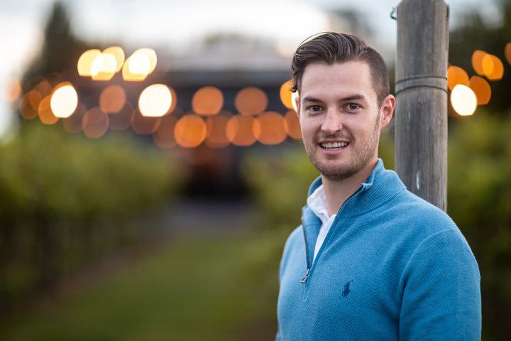 Wagga Wagga store promotional image of a man standing outdoors with warm evening lights in the background.