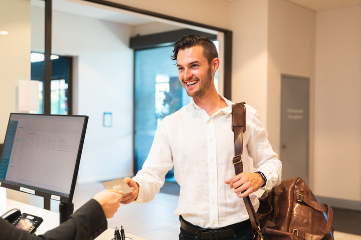 Mudgee store promotional image showing a customer smiling while handing over a card at a counter.