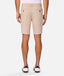 A man viewed from the back wearing light beige chino shorts, a white shirt, and white loafers with navy accents, set against a plain light gray studio background.