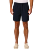 A man wearing dark navy blue drawstring shorts, paired with a white t-shirt and beige platform sneakers, standing against a light gray studio background.