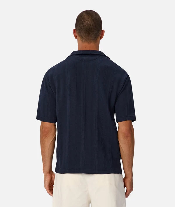 Man wearing a navy blue polo shirt on a white background