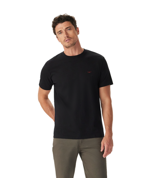A man wearing a black short-sleeve crewneck t-shirt with a small red embroidered logo on the left chest, paired with olive green pants, photographed against a solid white background.
