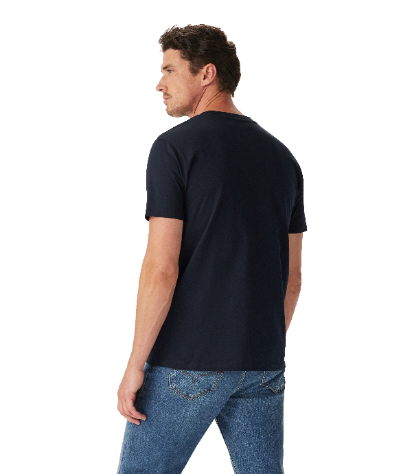 A man wearing a dark navy blue short-sleeve t-shirt and blue jeans, shown from a three-quarters back view against a solid white background.