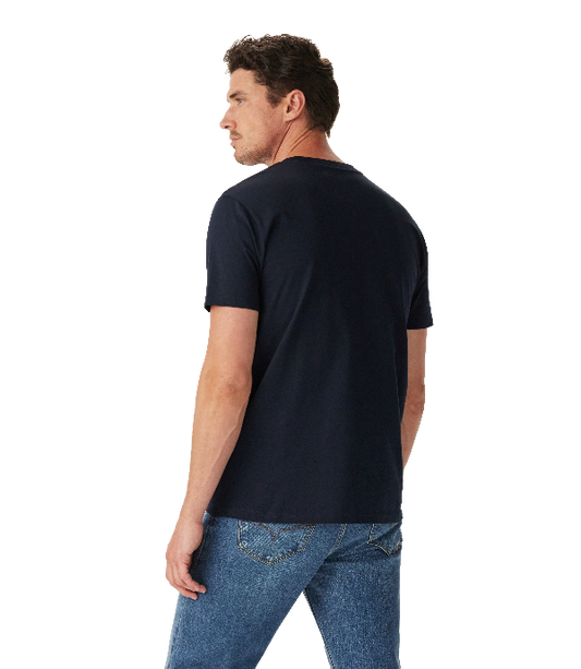 A man wearing a dark navy blue short-sleeve t-shirt and blue jeans, shown from a three-quarters back view against a solid white background.