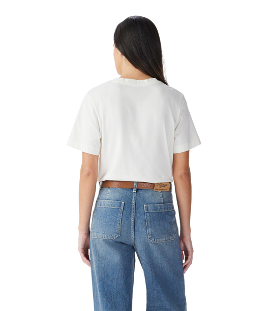 A woman viewed from the back wearing a white short-sleeve cropped T-shirt and blue jeans with a brown belt, against a plain white background.