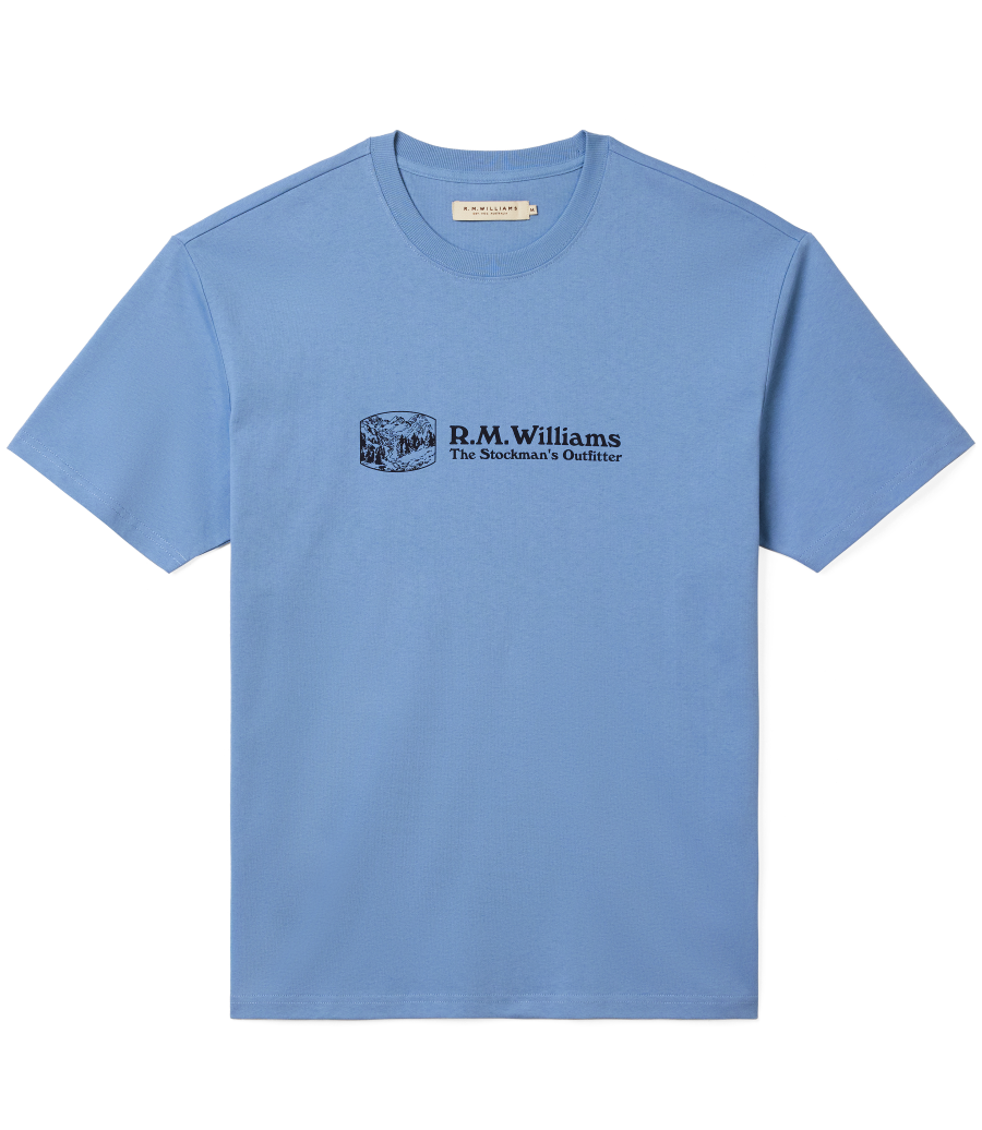 R.M.Williams - Outfitter T-Shirt - Soft Blue featuring a crew neck and branded print on a soft blue background.