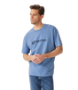 R.M.Williams - Outfitter T-Shirt - Soft Blue worn by a model, showcasing the crew neck and branded print.