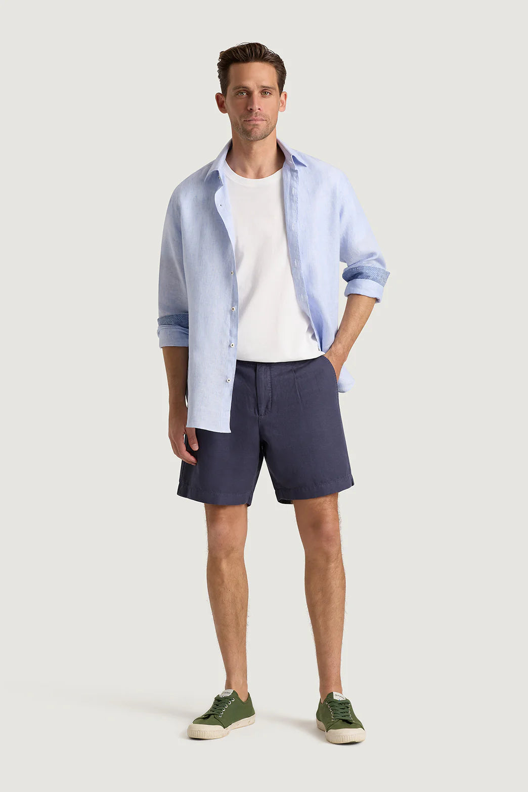 M.J. Bale - Menorca Side Tab Short- Denim model wearing a blue shirt and denim shorts with green sneakers.