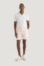 M.J. Bale - Menorca Side Tab Short- Pink worn by a model with a white polo shirt and sneakers.