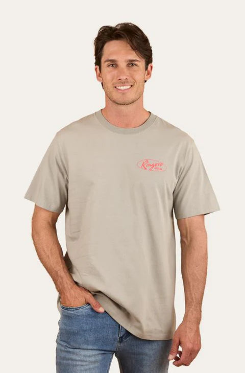 Ringers Western - Mud Sweat Beers Loose Fit T-Shirt - Cement worn by a man smiling while standing.
