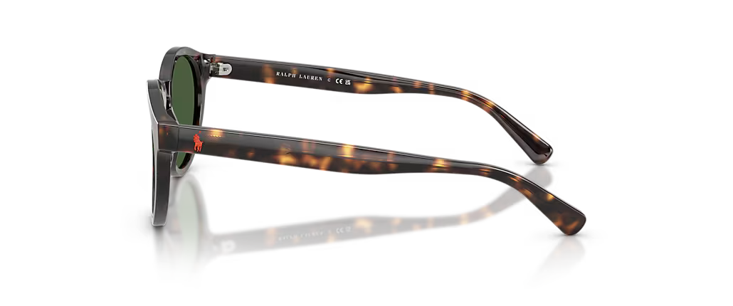 Ralph Lauren sunglasses with a dark brown and amber tortoiseshell acetate frame and green lenses, shown from a side profile on a reflective white surface.