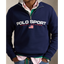 A man wearing a navy blue Polo Ralph Lauren quarter-zip sweatshirt over a pink collared shirt and green undershirt, paired with blue jeans.