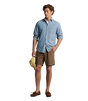 Man wearing brown linen shorts with a blue button up shirt. 
