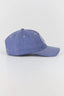 A blue denim baseball cap with white embroidered lettering on the side, photographed on a clean white studio background.