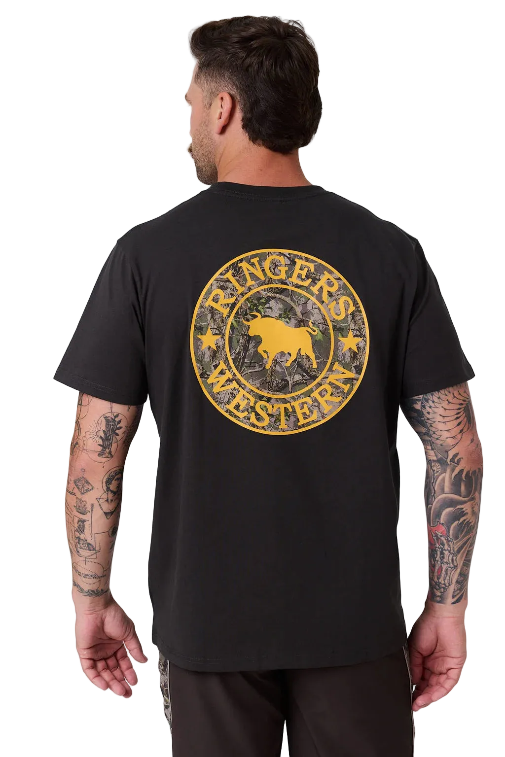 A man viewed from the back wearing a black t-shirt with a large distressed yellow circular graphic on the back that reads 'Ringer's Western' with a bull silhouette. The background is a clean, light gray studio backdrop.